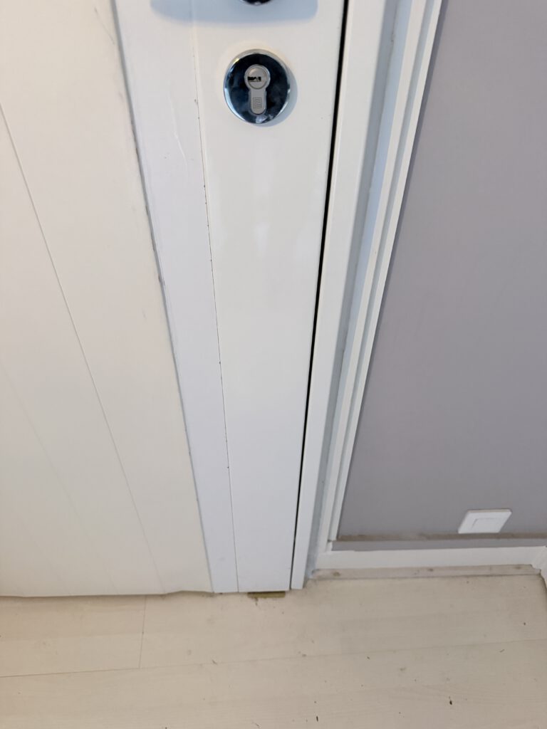 Gros plan cylindre de serrure sur porte blanche – remplacement de cylindre par serrurier d'urgence après cambriolage ou clé cassée