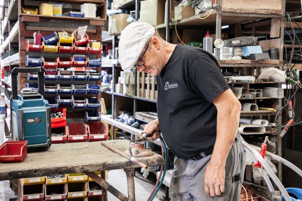 Artisan plombier brasant un tuyau en cuivre au chalumeau